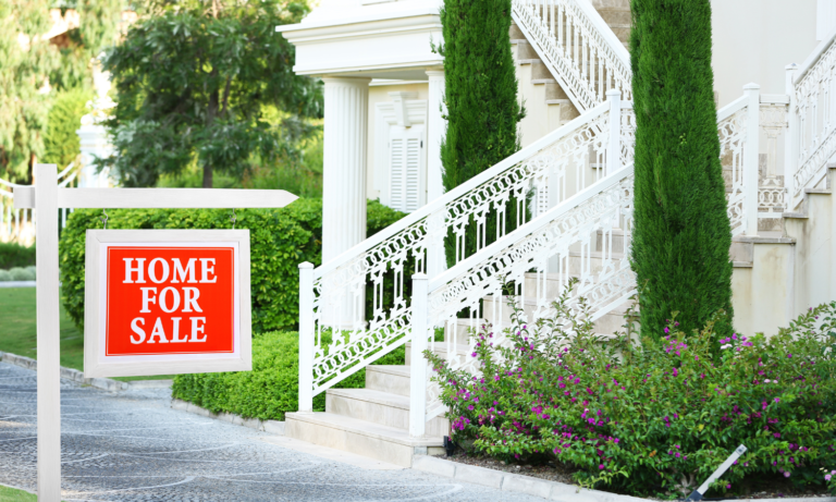 for sale sign in front of white house with white iron railing