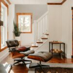 Professional homeowner thoughtfully reviewing architectural blueprints inside a bright, modern home, symbolizing strategic...
