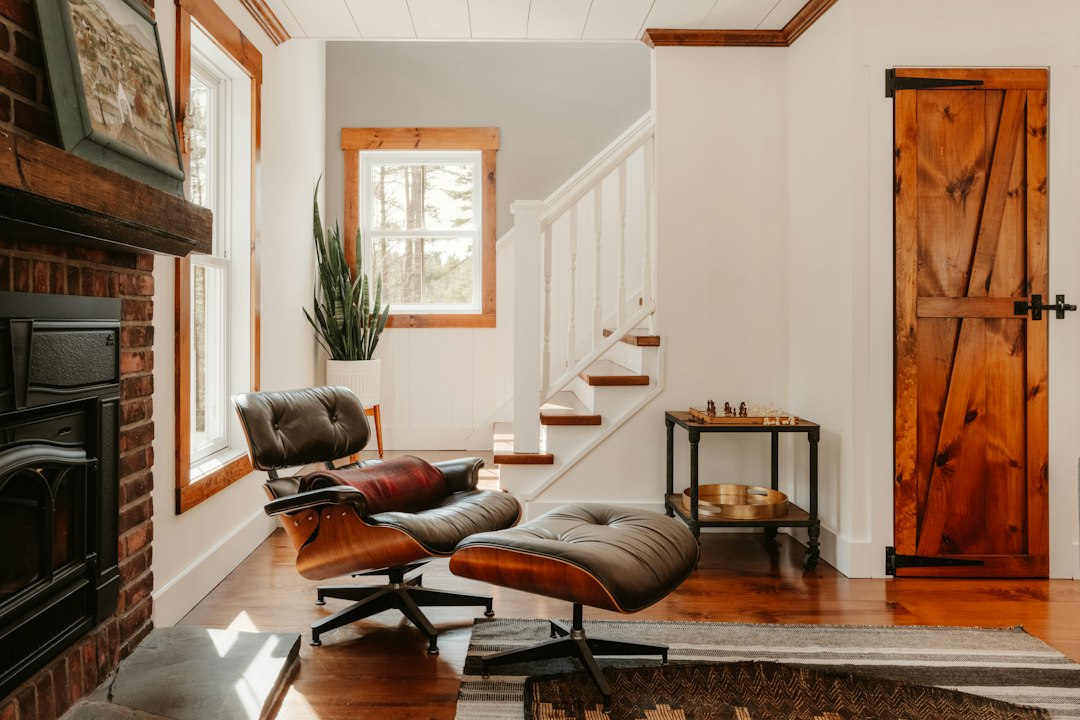 Professional homeowner thoughtfully reviewing architectural blueprints inside a bright, modern home, symbolizing strategic...
